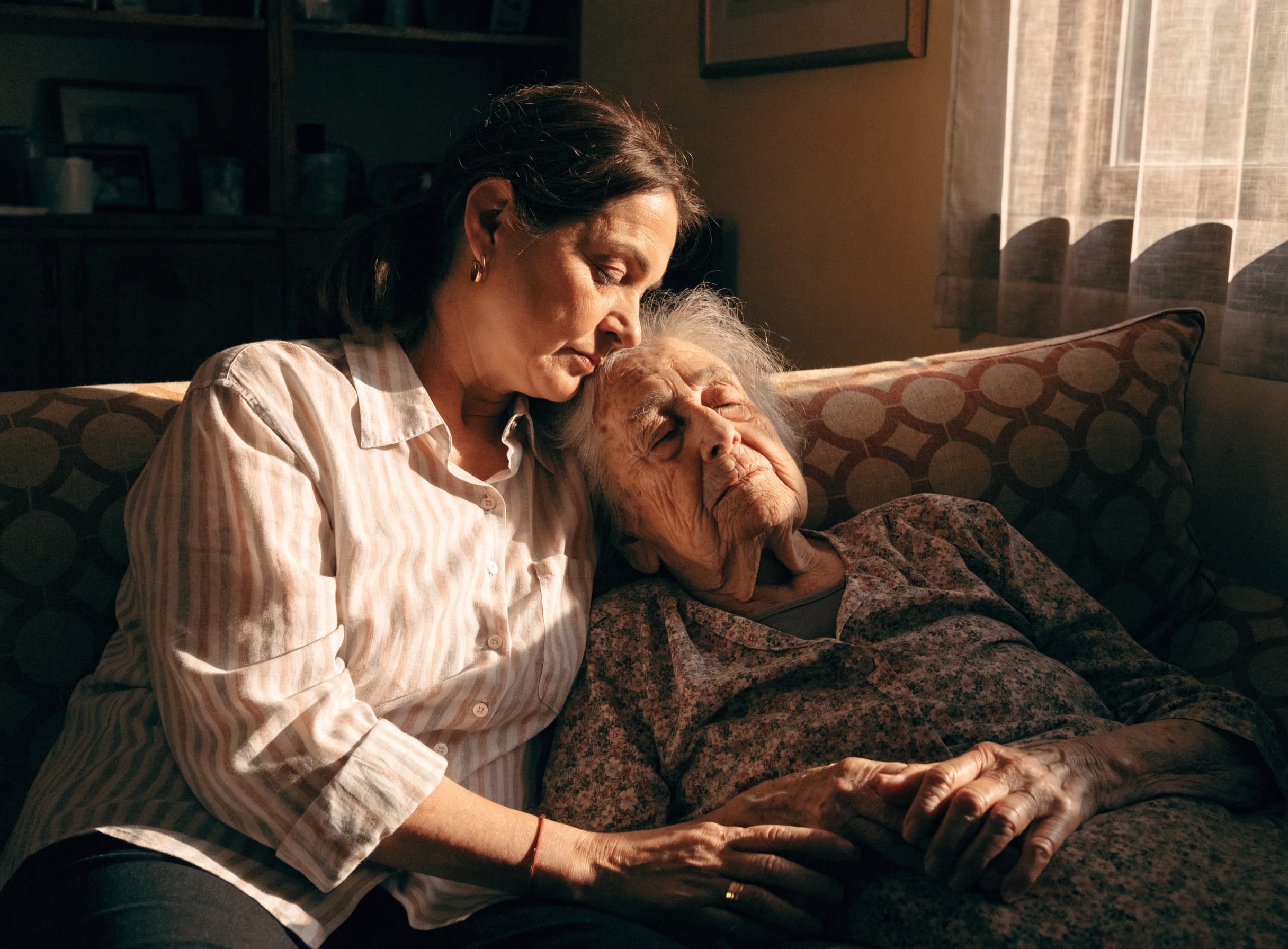 A daughter sharing a tender moment with her elderly mother at home
